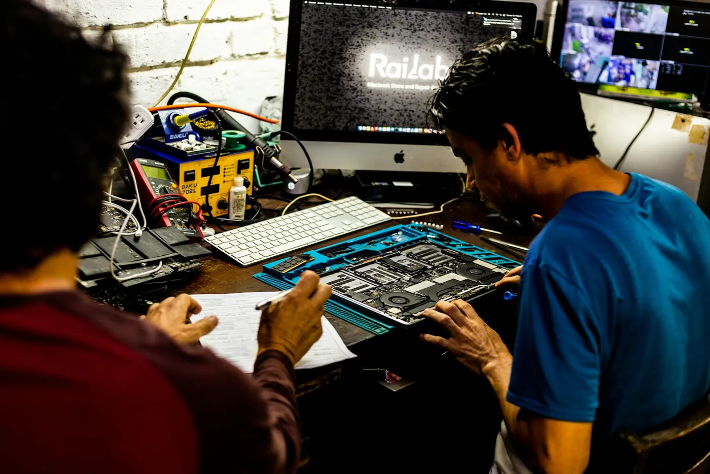 Técnicos avaliando a placa de um notebook